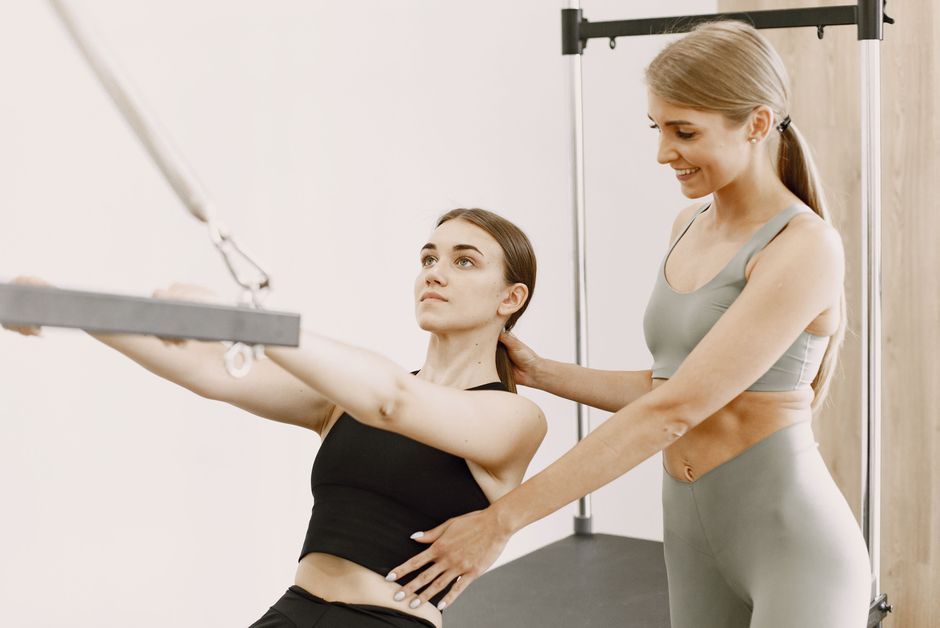Huấn luyện viên hướng dẫn hội viên sử dụng thiết bị