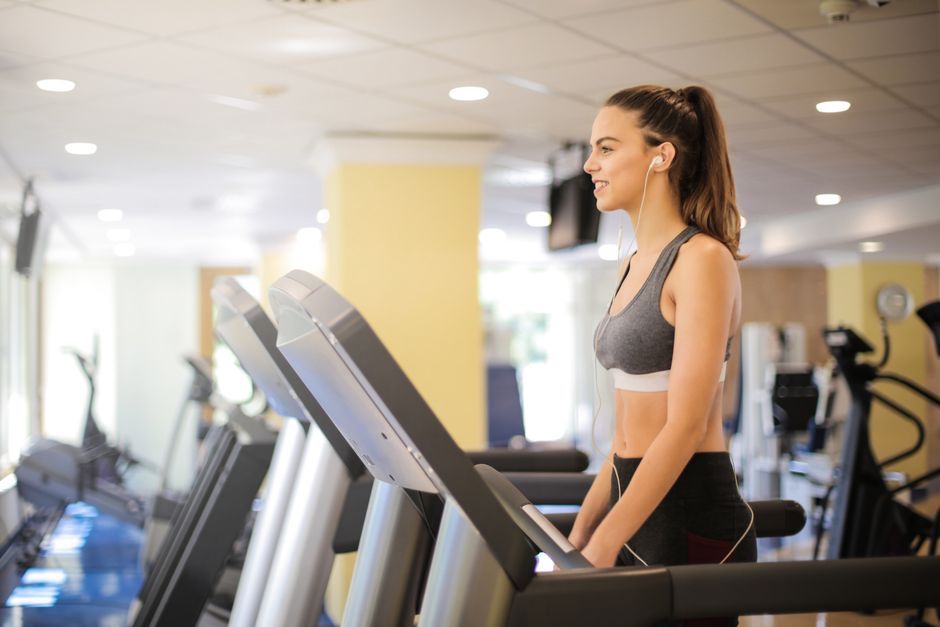 Người tập chạy trên máy chạy bộ trong phòng gym
