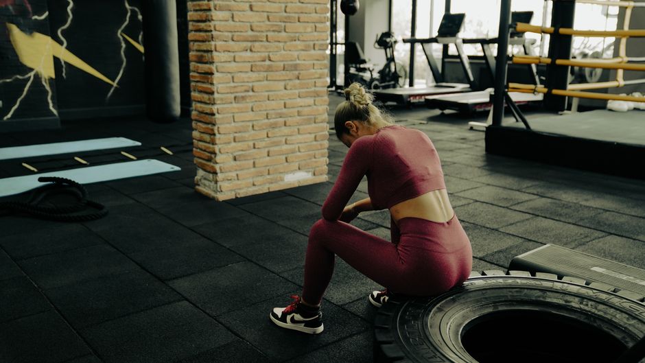 Người tập ngồi nghỉ giữa buổi tập trong phòng gym
