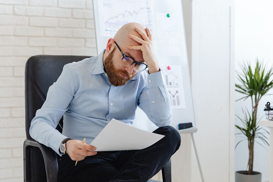 Chủ doanh nghiệp ngồi xem lại báo cáo tài chính