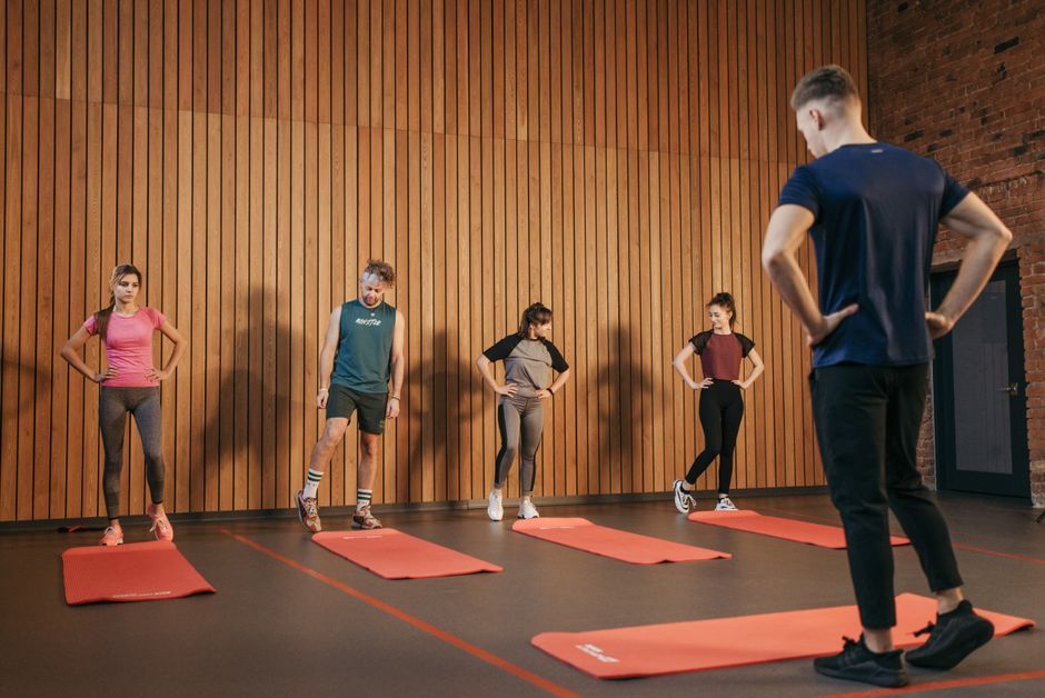 Huấn luyện viên dẫn một lớp tập nhóm trong phòng gym